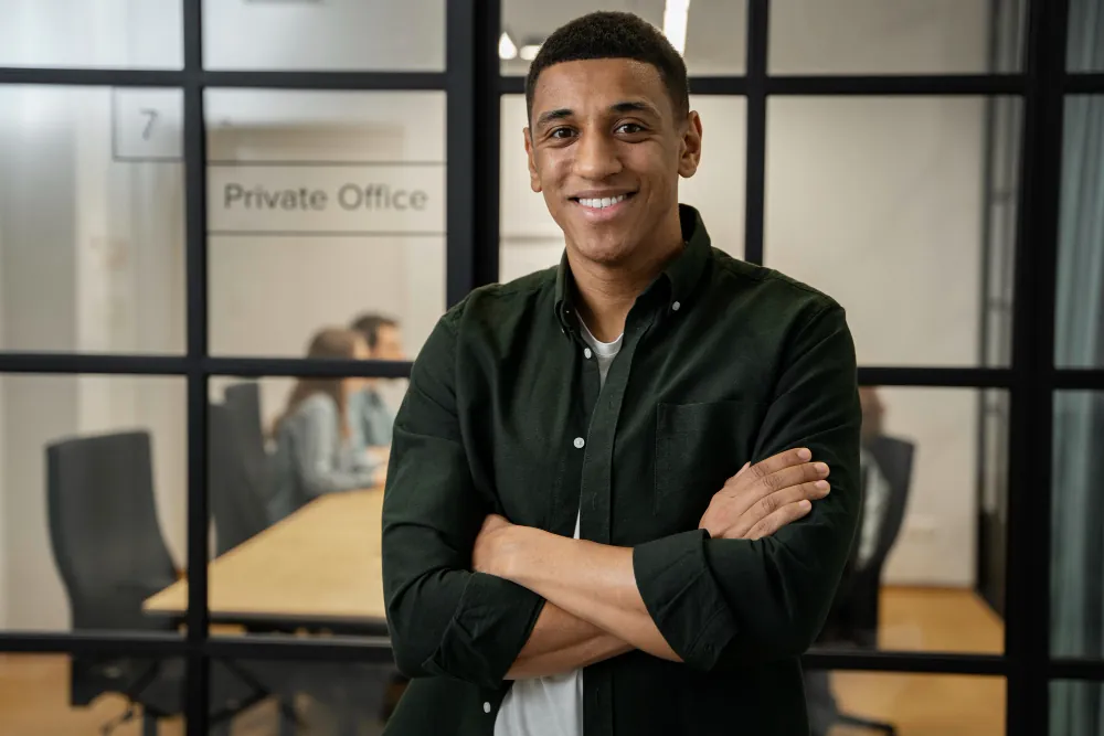 Software engineer standing confidently in a modern office