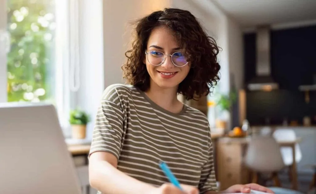 Student writing Solidity code at a home workspace